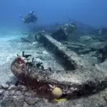 diver-swimming-above-the-large-metal-anchor