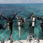 scuba-divers-enter-water-from-boat-via-giant-stride