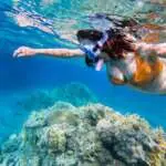 woman-snorkeling-above-coral-reef
